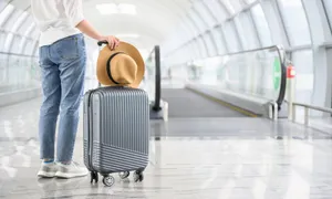 Traveler With Suitcase At Airport Terminal Wallpaper
