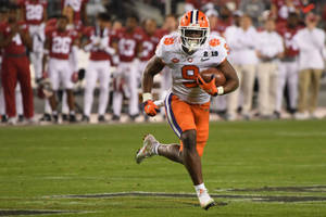 Travis Etienne Running In The Field Wallpaper