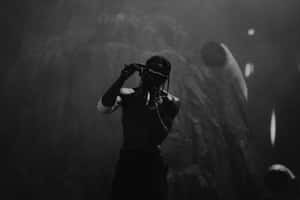 Travis Scott Performancein Dark Atmosphere Wallpaper