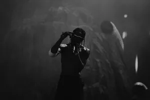 Travis Scott Performancein Dark Atmosphere Wallpaper