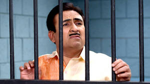 Tv Actor Dilip Joshi As Jethalal Behind Prison Bars Wallpaper