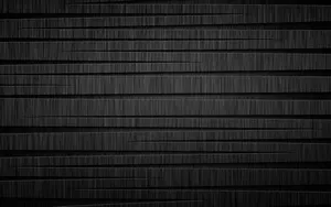 Two Black Metallic Cylinders Lying Against A White Backdrop Wallpaper