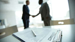 Two Businessmen Finalizing Contract Agreement Wallpaper