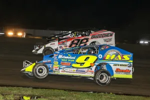 Two Dirt Race Cars Racing On A Dirt Track At Night Wallpaper