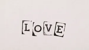 Two Loving Swans Forming A Heart In A Serene Lake Wallpaper