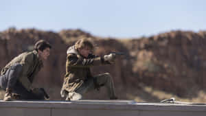 Two Men Are Pointing Guns At Each Other On A Roof Wallpaper