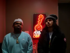 Two Men Standing Before Neon Sign Wallpaper