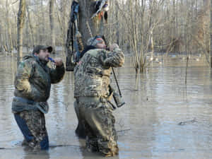 Two Men Standing In A Flooded Area Wallpaper