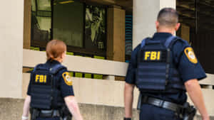 Two Police Officers Walking Down The Street Wallpaper