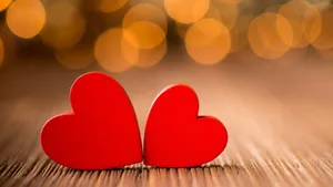 Two Red Hearts On A Wooden Table With Bokeh Background Wallpaper