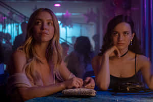 Two Women Sitting At A Table In A Bar Wallpaper