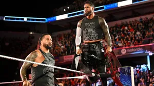 Two Wrestlers Standing On The Ring In Front Of A Crowd Wallpaper