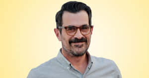 Ty Burrell Smiling On A Blue Background Wallpaper