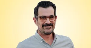 Ty Burrell Smiling On A Blue Background Wallpaper