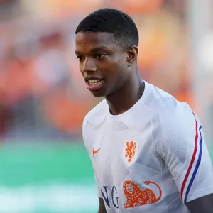 Tyrell Malacia Donning His Classic White Jersey On The Football Field Wallpaper