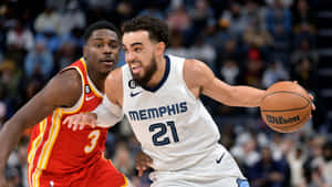 Tyus Jones, No. 21 Of Memphis Grizzlies, In Action On The Court. Wallpaper