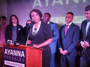 U.s. Representative Ayanna Pressley In A Profound Conversation Surrounded By Colleagues Wallpaper