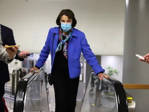 U.s. Senator Dianne Feinstein Wearing A Mask On An Escalator Wallpaper