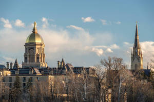 University Of Notre Dame With Leafless Trees Wallpaper