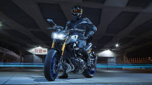 Unleashing Power - Rider With Black Yamaha Mt 15 Wallpaper