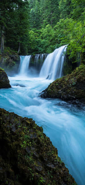 Unlock The Beauty Of A Flowing Waterfall Wallpaper