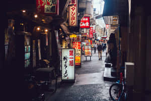 Unlock The Mysterious Power Of Tokyo At Night - A City Illuminated By The Light Of Progress And Shrouded In The Dark Of Doubt. Wallpaper