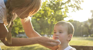 Unwell Child Comforted By Mother Wallpaper