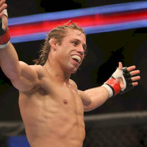 Urijah Faber Smiling And Raising Arms Wallpaper