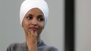 Us Representative Ilhan Omar Posing With A Contemplative Expression Wallpaper