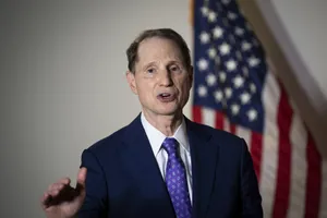 Us Senator Ron Wyden Standing Proud In Front Of The Us Flag Wallpaper