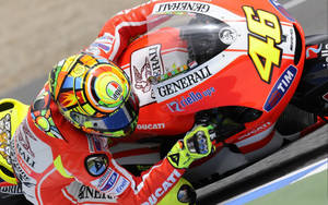 Valentino Rossi - Racer Extraordinaire Riding A Bold Red Ducati Wallpaper