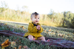 Very Cute Baby Sitting Outside Wallpaper