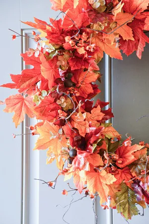 Vibrant Fall Wreath Adorning A Rustic Wooden Door Wallpaper