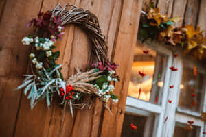 Vibrant Fall Wreath On Rustic Wooden Door Wallpaper
