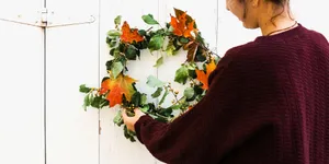 Vibrant Fall Wreath On Rustic Wooden Door Wallpaper