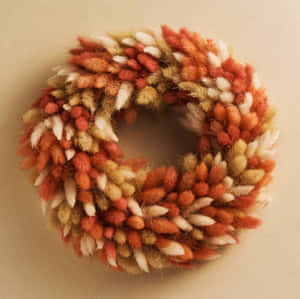 Vibrant Fall Wreath On Wooden Door Wallpaper