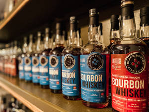 Vibrant Scene At Black Button Distilling With Rows Of Spirits On Display. Wallpaper