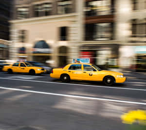 Vibrant Yellow Cab On City Street Wallpaper