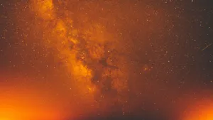 Vibrant Yellow Galaxy Swirling In The Cosmos Wallpaper