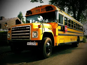 Vibrant Yellow School Bus On The Road Wallpaper