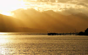 Vibrant Yellow Sunset Over The Tranquil Ocean Wallpaper