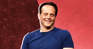 Vince Vaughn Striking A Confident Pose Against A Blue Backdrop Wallpaper