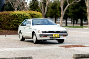 Vintage Isuzu Impulse Parked Outdoors Wallpaper