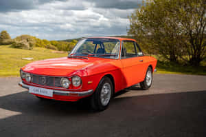 Vintage Red Lancia Coupe Parked Outdoors Wallpaper