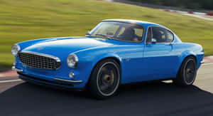 Vintage Volvo P1800 Cruising On The Highway Wallpaper