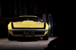 Vintage Yellow Corvette In Dark Garage Wallpaper