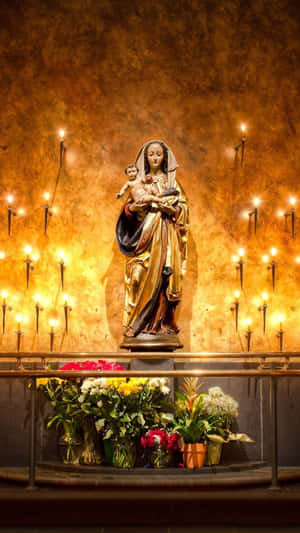 Virgin Mary Statuewith Candlesand Flowers Wallpaper