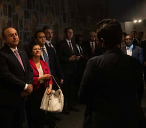 Visitors Listening At Kigali Genocide Memorial Wallpaper