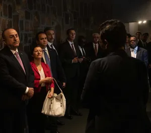 Visitors Listening At Kigali Genocide Memorial Wallpaper