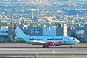 Viva Aerobus Airplane Against A Cityscape Wallpaper